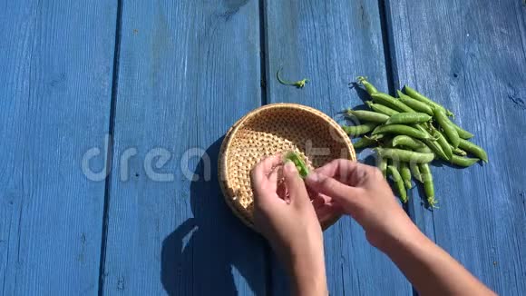 手荚壳壳外壳绿皮在柳条菜蓝色木桌上4K视频的预览图