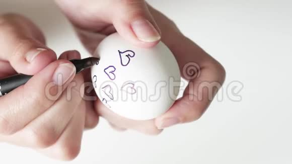 一个面目全非的女人拿着一个标记在复活节的一个破碎的鸡蛋上用黑色黑色的心关于这个概念视频的预览图