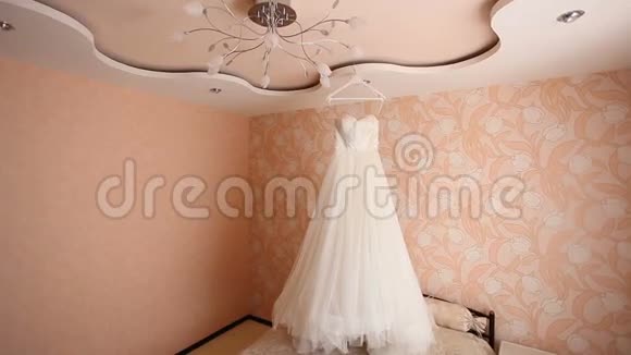 白色婚纱挂在粉红色的房间里视频的预览图