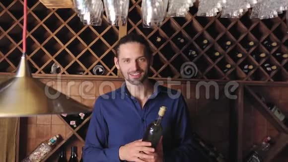酒厂餐厅酒窖里拿着酒瓶的微笑男子视频的预览图