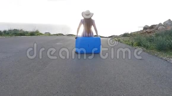 旅行者女人坐在她的手提箱上视频的预览图