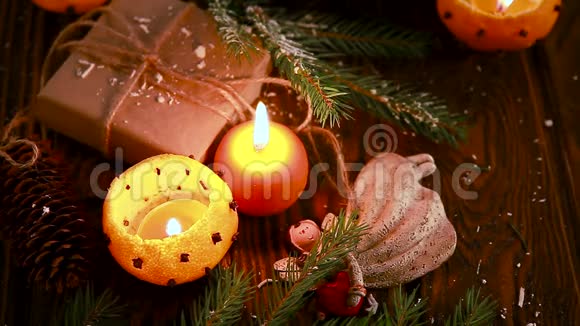 由曼达林制成的烛台有冷杉树枝玩具和木制桌子上的礼物圣诞节和新年背景视频的预览图