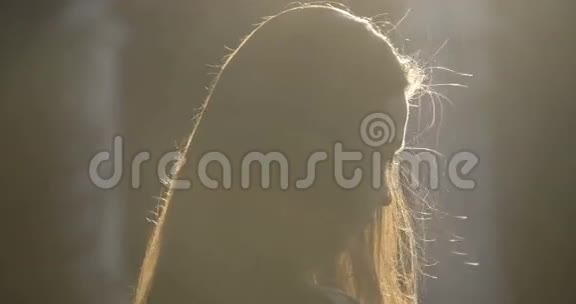 头发上有阳光的女人剪影视频的预览图