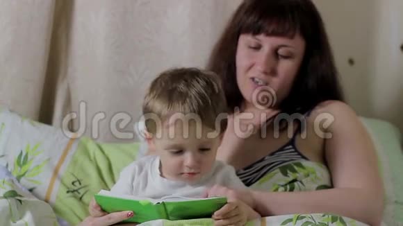妈妈在床上给孩子读一本书视频的预览图