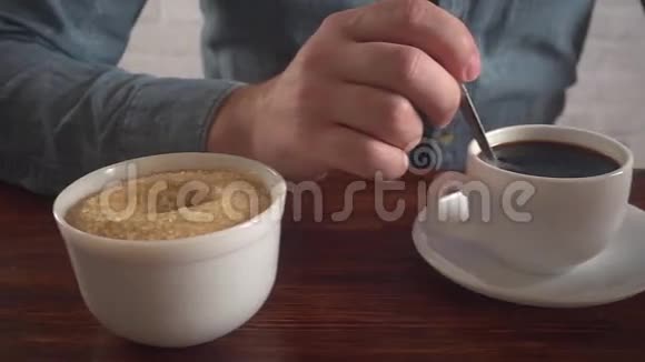 男人在咖啡里搅拌糖看着智能手机慢动作视频的预览图