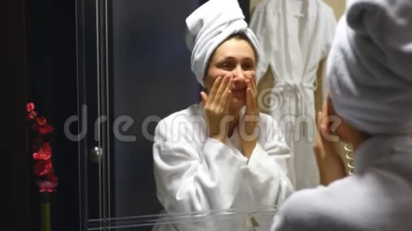 年轻漂亮的女人在浴室做脸部按摩视频的预览图
