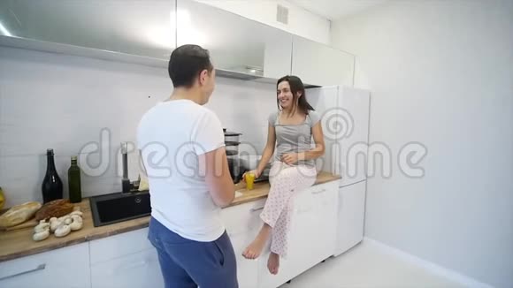 快乐夫妇一起在厨房做饭慢动作视频的预览图