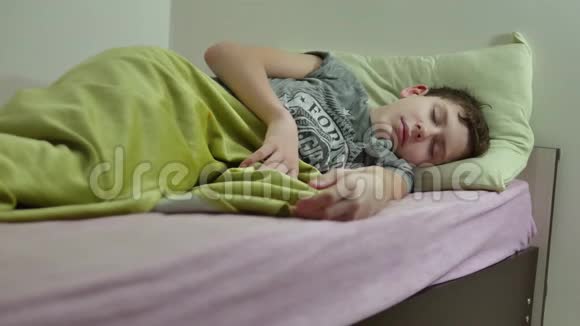 十几岁的男孩睡在床上疲惫的凌乱的室内少年睡觉视频的预览图