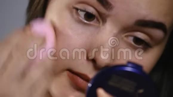 美容化妆品特写美丽的女人应用色调奶油基地在脸上有魅力的年轻女性肖像视频的预览图