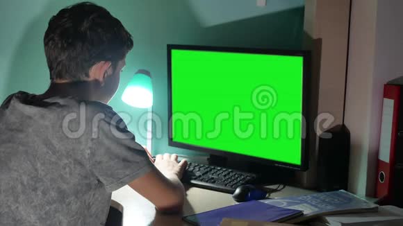 绿色钥匙在室内青少年男孩玩电脑特写手游戏视频坐回去青年学生考试视频的预览图