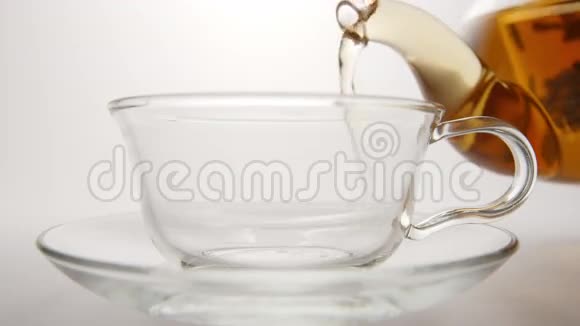 新鲜的茶从茶壶里流入茶杯视频的预览图