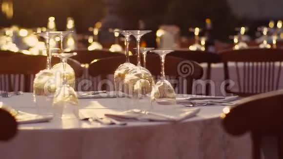 准备好的桌子有空的闪亮酒杯新鲜的冰水瓶白色餐具和舒适的木椅视频的预览图