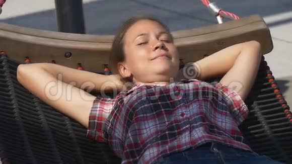 在城市公园的吊床上打盹的美女视频的预览图