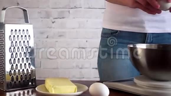女人把鸡蛋塞进碗里碗站在秤上烹饪概念视频的预览图