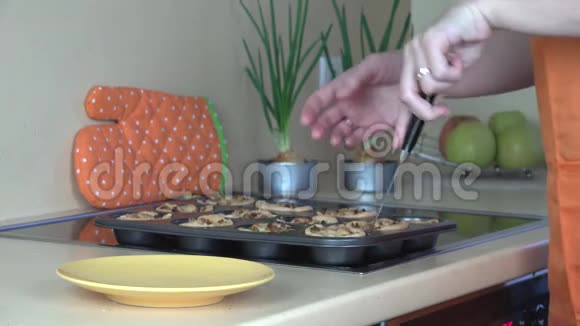 女人的手从饼盘里拿出烤肉杯蛋糕放在盘子里视频的预览图