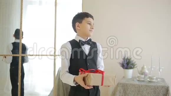 戴领结的快乐男孩拿着礼物视频的预览图