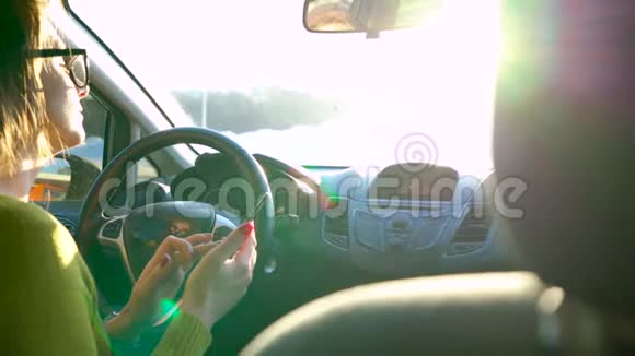戴眼镜的女人用智能手机在车里喝咖啡视频的预览图