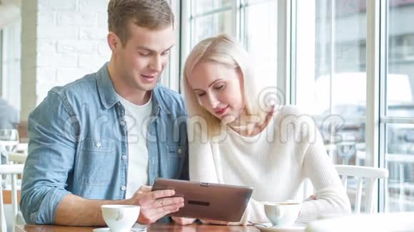 这对年轻夫妇正忙着在餐馆吃平板电脑视频的预览图