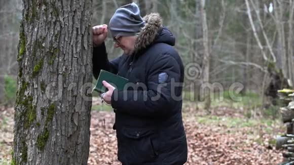 一个悲伤的人带着圣经和念珠靠近树视频的预览图