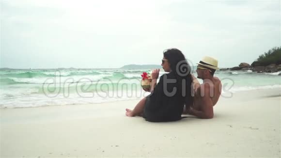 情侣在热带海滩上喝椰子视频的预览图