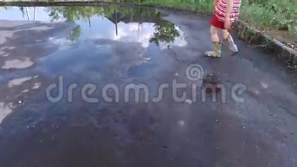 女孩穿过水坑这个女孩很高兴雨结束了视频的预览图