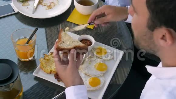 早餐包括鸡蛋面包橙汁和少许黄油视频的预览图