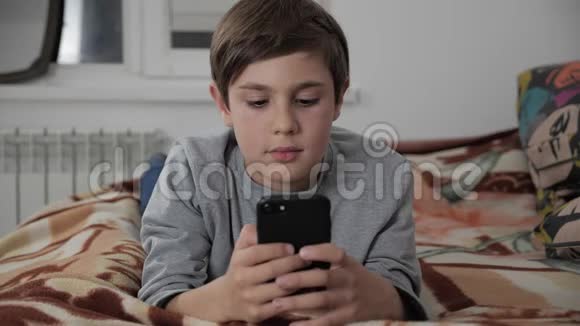 小孩在家玩手机小孩用智能手机躺在床上视频的预览图