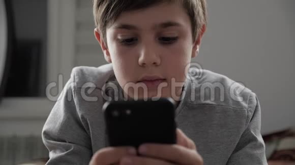 小孩在家玩手机小孩躺在床上使用智能手机视频的预览图