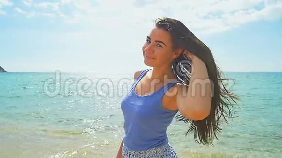 海滩上的女人肖像阳光明媚的海滩和清澈的碧水慢动作视频的预览图