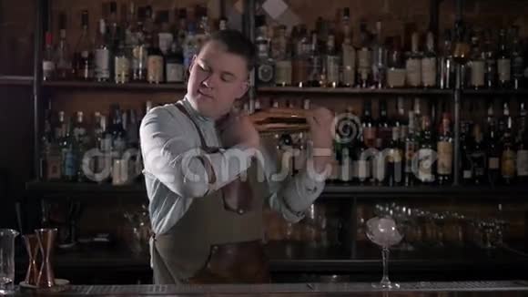 带摇床的酒保在现代酒吧做鸡尾酒英俊的酒吧男摇饮料视频的预览图