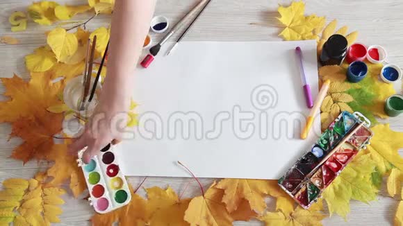 艺术家用秋叶在桌子上安排创意的物品视频的预览图