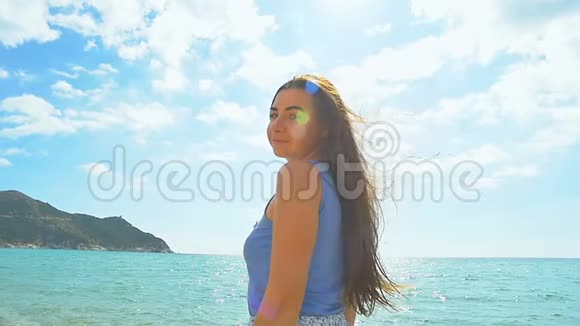 海滩上的女人肖像阳光明媚的海滩和清澈的碧水慢动作视频的预览图
