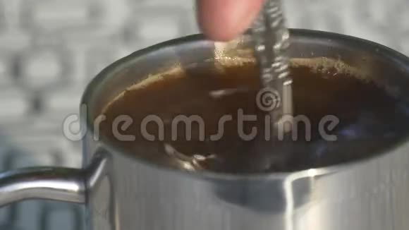 一个人在户外的咖啡里搅拌糖视频的预览图