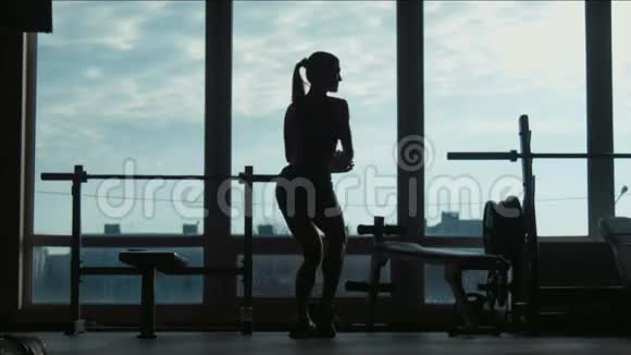 漂亮女人的轮廓在健身房里摆姿势和展示肌肉视频的预览图