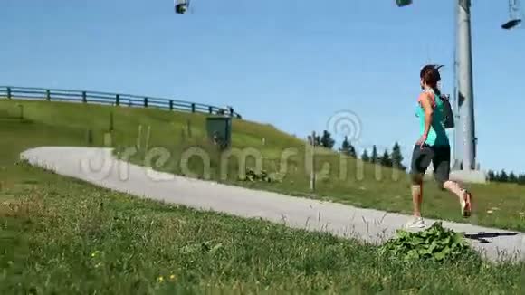 Ypung女士在一个美丽的日子里慢跑背部有一个滑雪电梯视频的预览图