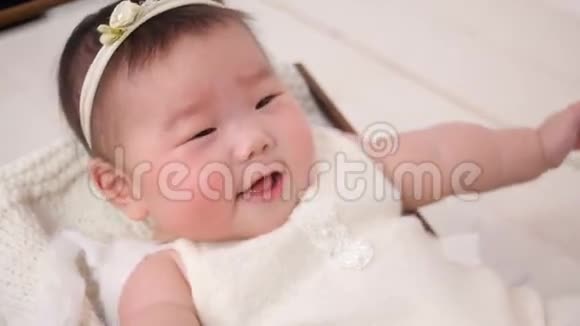 小亚洲女孩孩子是婴儿车婴儿床穿着白色西装视频的预览图