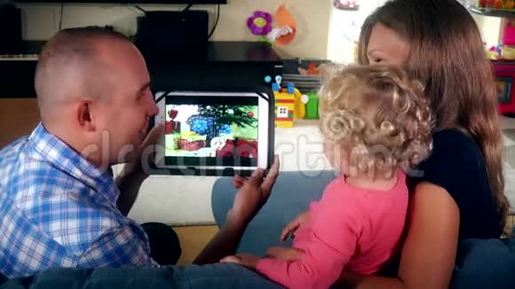 可爱的家庭孩子父亲和母亲在平板电脑上看家庭视频电影视频的预览图