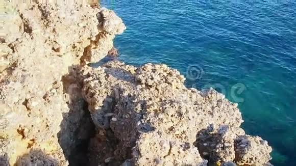 岩石海岸有清澈的蓝色水视频的预览图