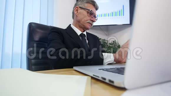 商人用手在木桌上打手提电脑并做一些笔记视频的预览图