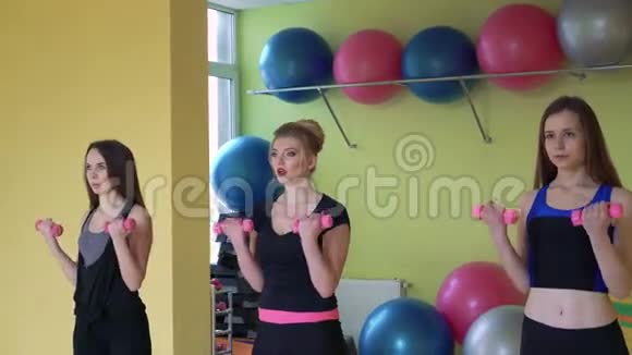 女性团体在健身房同步做哑铃运动4k视频的预览图