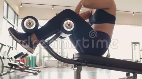运动女性在健身馆里坐在仰卧起坐上人们的生活方式和锻炼体育训练俱乐部的活动视频的预览图