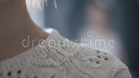 乳白色床上用品的时尚针织毛衣婀娜多姿的瘦脖子一个迷人的女孩我温柔的微笑视频的预览图