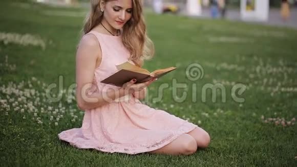 公园草坪上的女孩在看书梦想着爱情视频的预览图