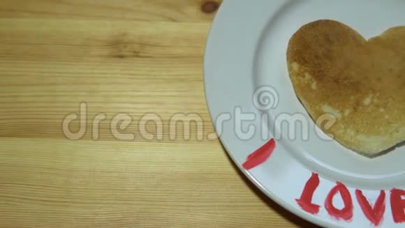 一个盘子里面有一个心形的煎饼一个杯子桌子上有咖啡视频的预览图