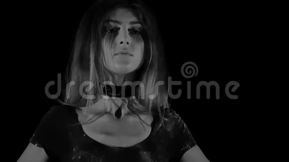 一个年轻的女人穿着黑色背景的白色空面粉视频的预览图