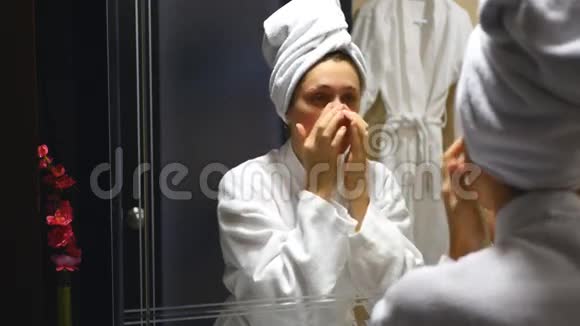 年轻漂亮的女人在浴室做脸部按摩视频的预览图