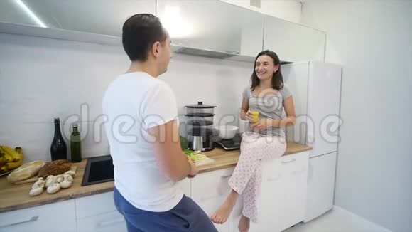 快乐夫妇一起在厨房做饭慢动作视频的预览图