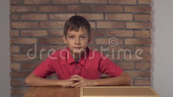坐在办公桌前的孩子拿着一张挂图背景上红砖墙上刻着字母的老板视频的预览图
