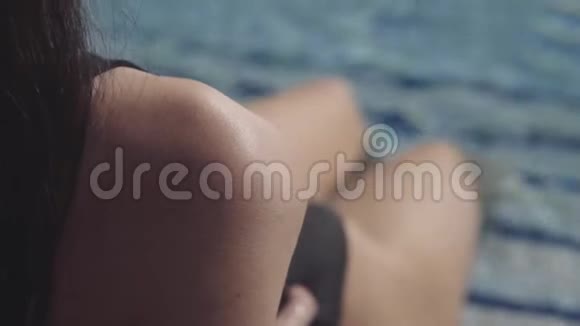 美丽的女孩躺在游泳池和日光浴池里视频的预览图