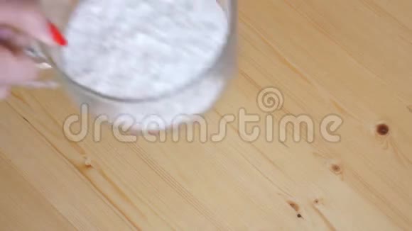 女人把盐小苏打和糖和面粉混合在一起视频的预览图